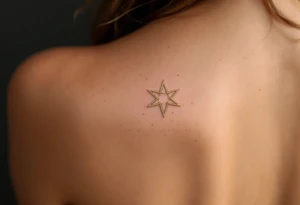 A shimmering gold eight-pointed star tattoo evokes celestial power and divine energy. tattoo idea
