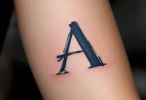 A brushstroke "A" in deep navy blue, fading into a smoky gray. tattoo idea