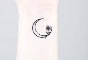 Small black and white tattoo waxing crescent moon with small Daisy birth flower and tiny leo gliph tattoo idea