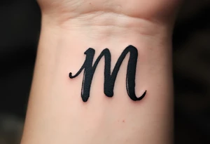 A handwritten "M" in ink-wash black, giving it a natural, imperfect flow. tattoo idea