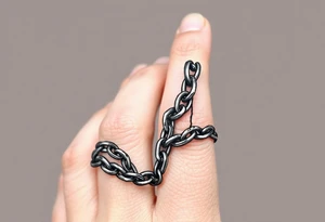 Chains wrapped on thumb and pointer finger connecting together tattoo idea