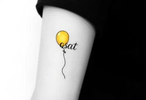 small yellow balloon with letters osaat on bicep tattoo idea