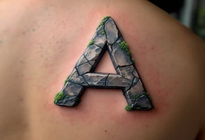 A cracked stone "A" in granite gray with mossy green details. tattoo idea