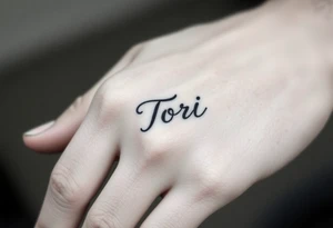 Hand tattoo with the name Tori on a man’s hand tattoo idea
