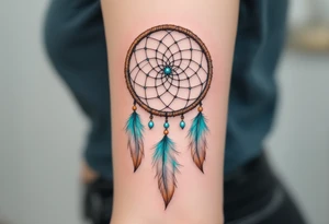 Dreamcatcher (česky lapač snů) tattoo featuring soft turquoise and beige feathers, a brown woven hoop with light blue beads, symbolizing protection and peaceful dreams in a delicate, boho style. tattoo idea
