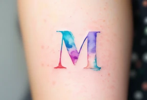 A watercolor "M" in blended shades of teal, lavender, and coral, with a brushstroke effect. tattoo idea