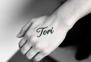 Hand tattoo with the name Tori on a man’s hand tattoo idea