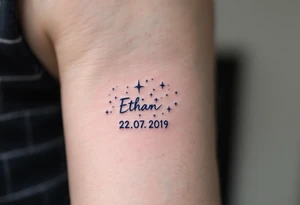 Ethan 22. 07. 2019 – Bold navy blue and silver stars scattered across a night sky, with Ethan's birthdate in a white, handwritten font. tattoo idea
