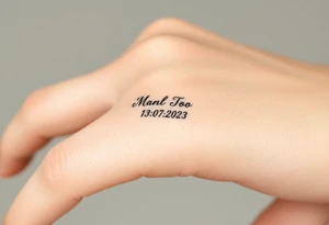simple and elegant black ring with a delicate engraving of the wedding date tattoo idea