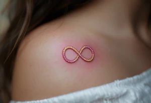 Two interlocking infinity symbols in gold and rose pink, representing eternal mother-daughter love. tattoo idea