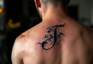 Elegant monogram-style "J" in ink-washed navy with gold leaf highlights. tattoo idea