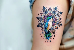 Colorful hummingbird centered in front of a mandala design tattoo idea