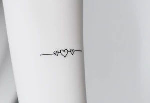 A minimalist infinity symbol with two tiny hearts at the end of each loop, rendered in a thin, black ink for a subtle, timeless look tattoo idea