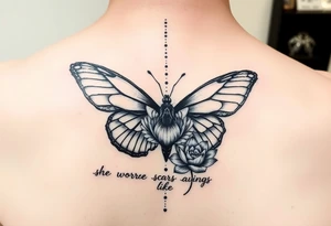 butterfly with cracked wings and lotus flower with quote that says “she wore her scars like wings” all down spine but very elegant tattoo idea