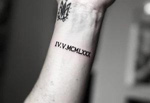 Minimalist IV.V.MCMLXXX tattooed in fine-line black ink on the inner forearm for a birthdate tribute. tattoo idea
