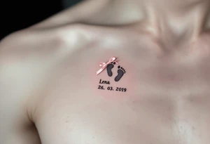 A tiny footprint in soft gray with a pink ribbon tied around it, personalized with a birthdate Lena 26. 03. 2019. tattoo idea