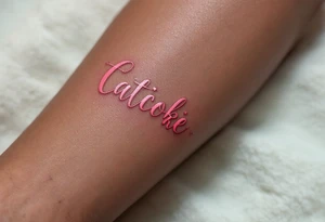 Pink ink lettering on darker skin, glowing subtly like chalk on a blackboard, surrounded by geometric shapes. tattoo idea