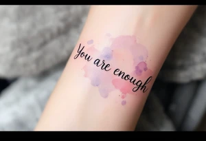 “You are enough” in dusty rose with a faint watercolor background of pastel blues and pinks. tattoo idea
