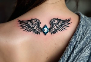 A pair of black ink wings cradling a small, blue gem with the son’s initials KS inside. tattoo idea