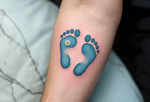 Light blue and soft gray footprints of Jakub, encircled by a small, blooming daisy to signify his pure and gentle spirit. tattoo idea