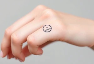 simple and elegant black ring with a delicate engraving of the wedding date or the partners' initials tattoo idea