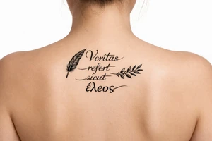 Veritas refert sicut ἔλεος on mid back slightly to the  right with the words stacked not perfectly aligned with a delicate but clear quill at the beginning and an olive branch at the end and there should be Elegant curvature as a vibe do not connect anything Think ballet chic black Swan tattoo idea