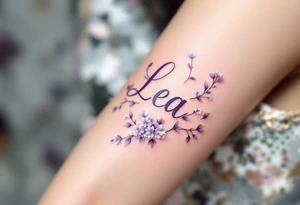 Lea name written in elegant script, surrounded by delicate lilac vines with small white blossoms. tattoo idea