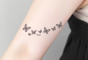 Six different butterflies streaming down arm with six kids names Aden, Aninna, Novaih, Rayla, Jayla, Teresa tattoo idea