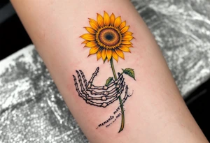 A skeleton hand holding a dying yellow sunflower, quote "memento mori" in thin, winding black cursive along the stem. tattoo idea