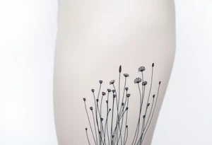 A field with long grass and flowers with mountains in the background tattoo idea