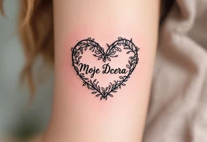 A delicate black and pink line-art heart with the word “Moje Dcera” written in elegant cursive across the center. tattoo idea