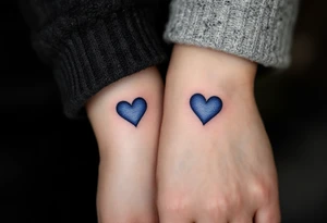 Matching tiny navy-blue heart tattoos on ring fingers of each partner tattoo idea