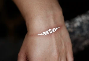 A thin, delicate gold band with intricate white filigree engravings, symbolizing timeless elegance and devotion. tattoo idea