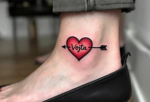 A classic red heart pierced by an arrow, bearing the name Vojta along the curve. tattoo idea