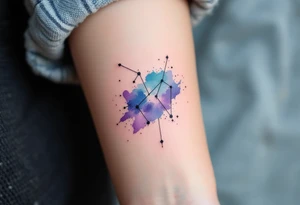A watercolor-style Sagittarius constellation in shades of indigo, teal, and violet splashed across the forearm like a night sky. tattoo idea