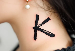 Brushstroke K painted with bold black ink, Japanese sumi-e style with subtle red stamp mark in the corner. tattoo idea