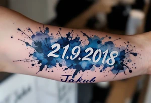 Bold numbers "21.9.2018 v 7:30" with the name "Jakub" beneath, surrounded by a blue watercolor splash. tattoo idea