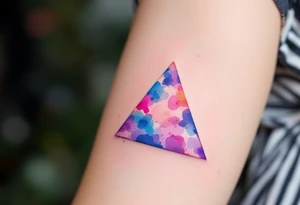 A watercolor triangle filled with splashes of blue, pink, and purple, representing creativity and fluidity. tattoo idea