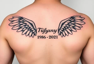 Simple Angle wings with Tiffany in the middle and 1978-2021 under it tattoo idea