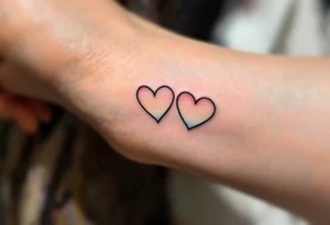 Tiny matching rainbow hearts behind each ear to honor love in every shade. tattoo idea