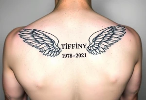 Simple Angle wings with Tiffany in the middle and 1978-2021 under it tattoo idea