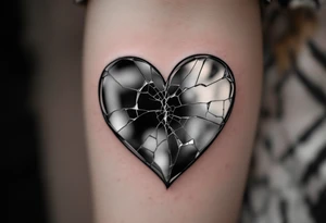 A heart-shaped mirror, cracked in the center, reflecting distorted memories of love in grayscale tones. tattoo idea