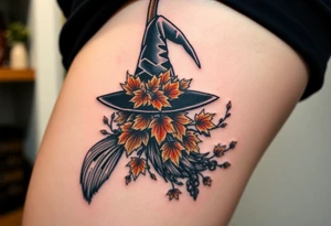 Which is broom with handle
 a witches hat with fall maple leaves, feathers and vines tattoo idea