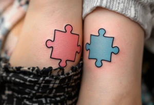 Interlocking puzzle pieces in soft pink and muted blue on the inner wrists symbolize how perfectly you fit together. tattoo idea