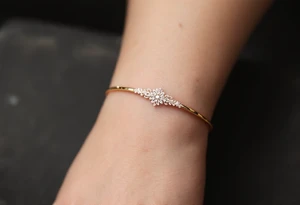 A thin, delicate gold band with intricate white filigree engravings, symbolizing timeless elegance and devotion. tattoo idea