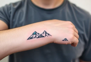 A pair of minimalist black and blue mountain peaks, one tattooed on the father’s forearm and the matching smaller version on the child’s. tattoo idea