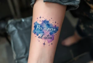 A celestial forearm piece features “Per aspera ad astra” in silver cursive beneath blue-and-purple watercolor stars. tattoo idea