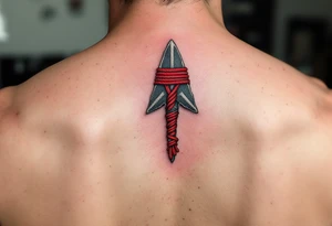 A hand-carved flint arrowhead in gray with red cord wrapping, symbolizing strength and survival tattoo idea