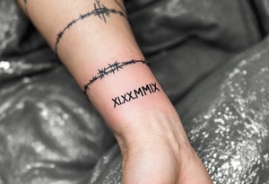 XI.XI.MMIX inked in matte black on the hand’s edge, accompanied by silver barbed wire surrounding it. tattoo idea