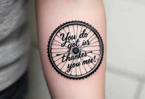 A motivational quote wrapped around a bike wheel, in elegant cursive script with subtle navy blue accents. tattoo idea